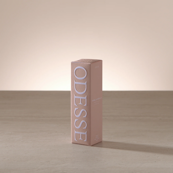 Pink 'ODESSE' box on a wooden surface with a neutral background