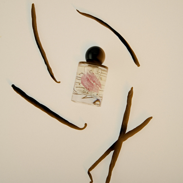 Vanilla extract bottle with vanilla beans on a light background
