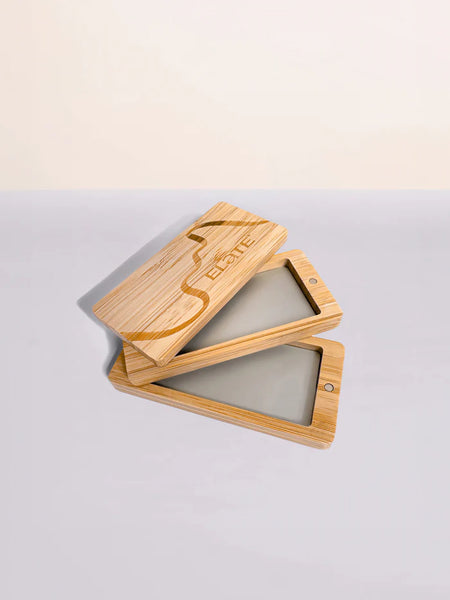 Two wooden phone cases on a light gray surface with a beige background