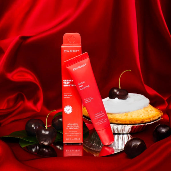 Two red skincare products on a red fabric background with cherries and a cupcake.