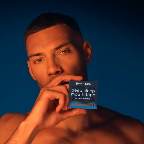 Man holding a box of 'deep sleep mouth tape' against a blue background