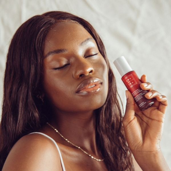 Woman holding a bottle of The Sunscreen Company Ava Isa Sun-e-Serum Drops SPF 35