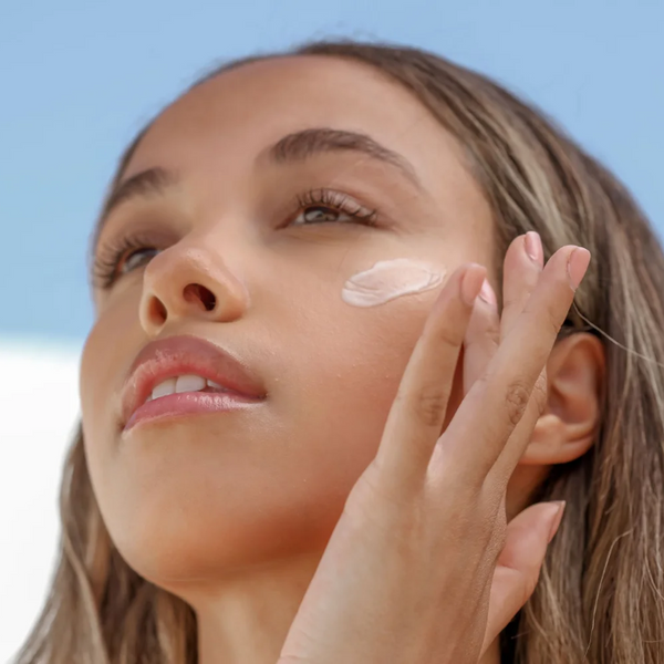 Person putting on The Sunscreen Company Ava Isa Sun-e-Serum Drops SPF 35