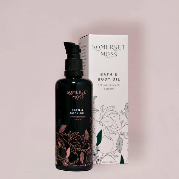 Bottle and packaging of Somerset Moss bath and body oil on a light pink background