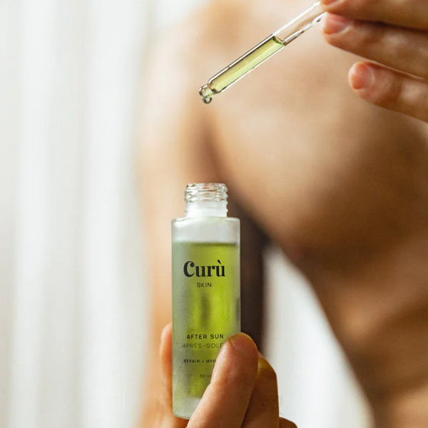 Person holding a bottle of Curu Skin After Sun Facial Oil