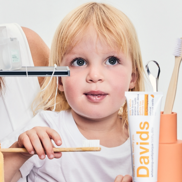 child using Davids Hydroxyapatite kids orange vanilla toothpaste