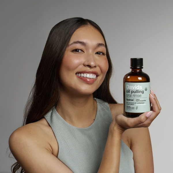 person holding bottle of Davids Nano Hydroxyapatite Oil Pulling Oral Rinse