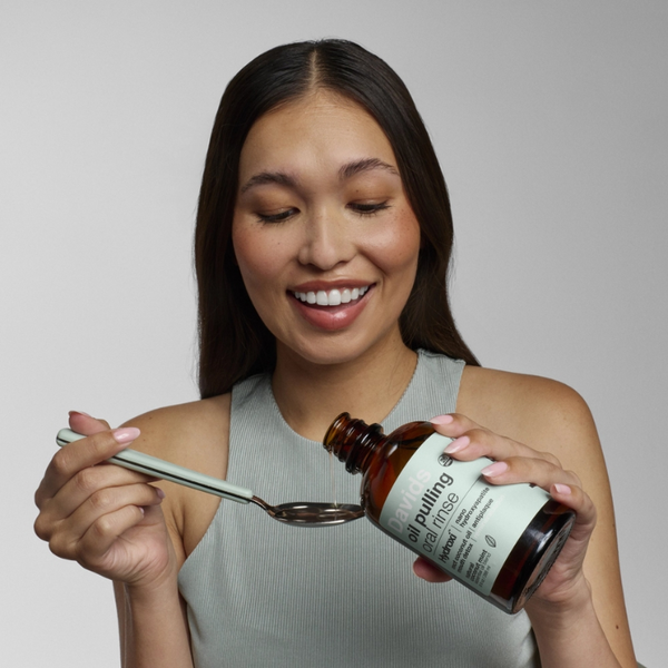 person using Davids Nano Hydroxyapatite Oil Pulling Oral Rinse