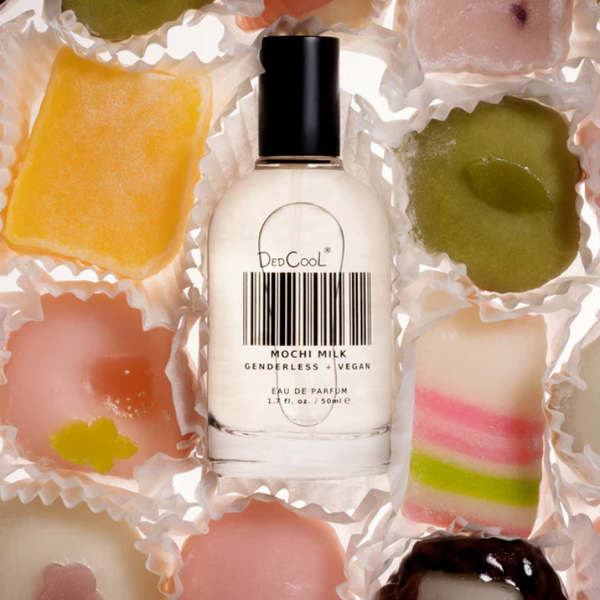 Bottle of 'Din Good' Mochi Milk perfume surrounded by colorful mochi candies.