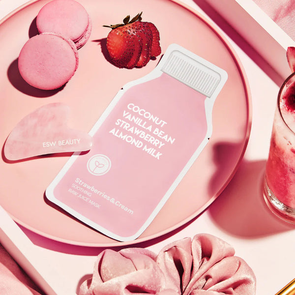 Coconut Vanilla Bean Strawberry Almond Milk Mask on a pink plate with macarons and a glass of pink drink, featured in the Strawberry Sweets Skincare Treats Set