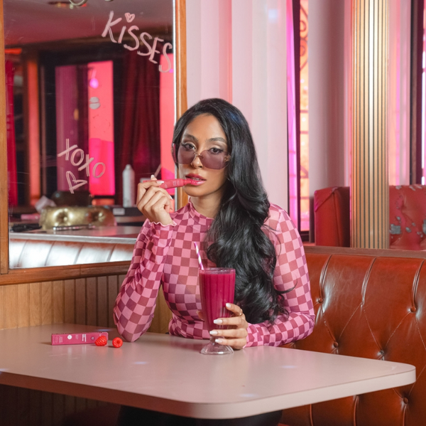 Woman using ESW Beauty Raspberry Acai Smoothie lip treatment