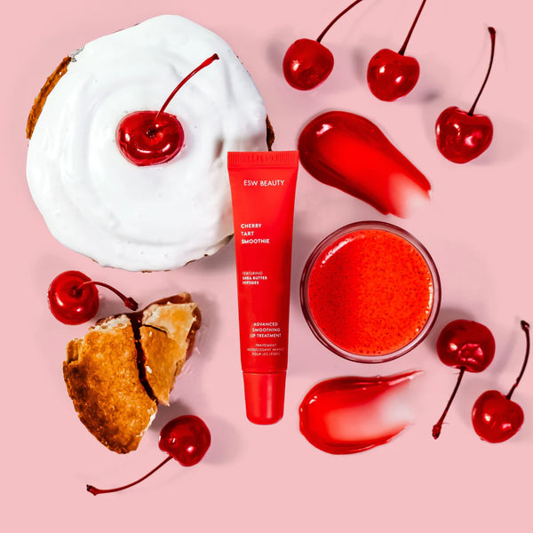 Red skincare product with cherry-themed items on a pink background