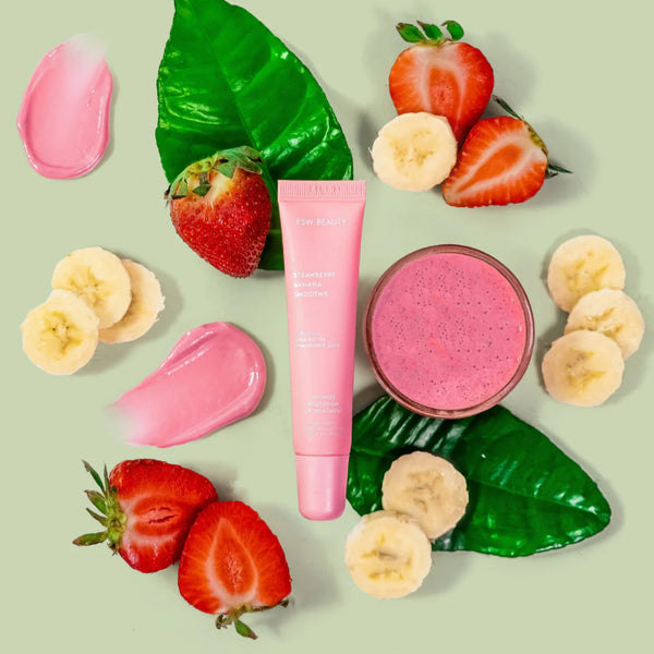 Pink Strawberry Banana Smoothie Lip Treatment with strawberry and banana slices on a green background