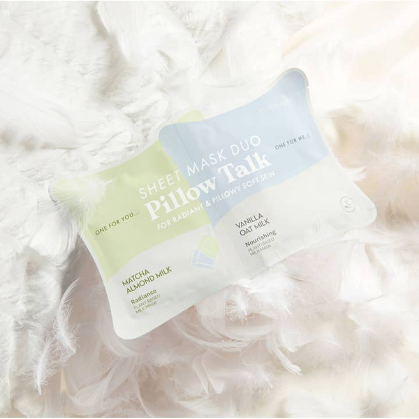 Two sheet masks from Pillow Talk on a fluffy white surface