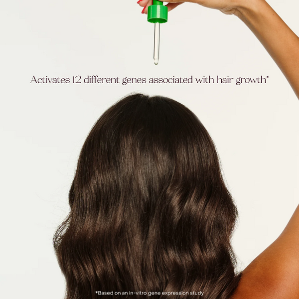 Person with long, dark hair holding a dropper with text about gene activation for hair growth. Everist EverBoost Peptide Serum