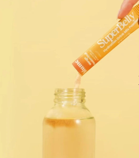 Blume Mango Passionfruit SuperBelly product being applied to a bottle with a yellow background