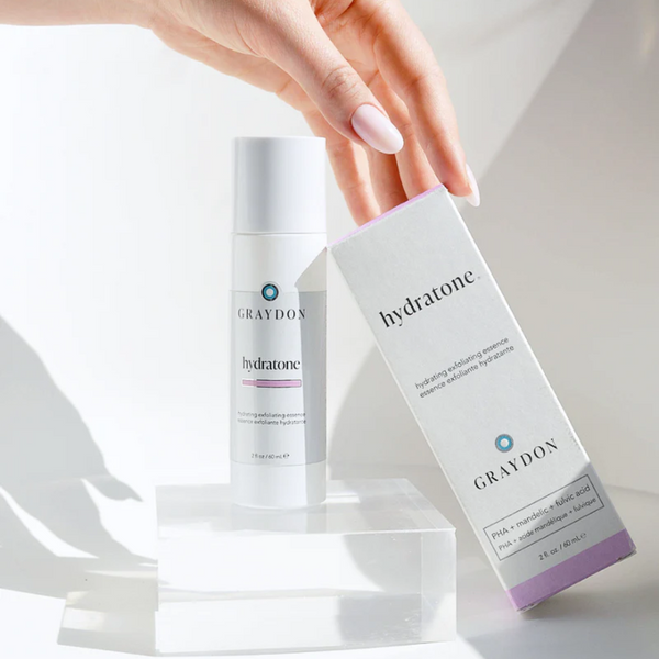 Hand holding a box of Graydon Hydratone Exfoliating Essence
