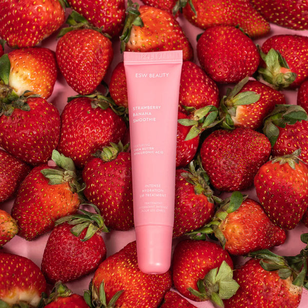 Strawberry Banana Smoothie Lip Treatment tube surrounded by strawberries