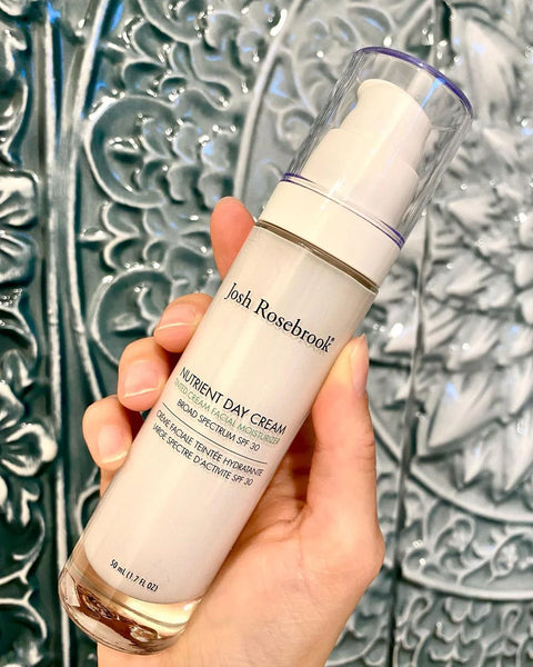 person holding bottle of Josh Rosebrook Tinted SPF Moisturizer