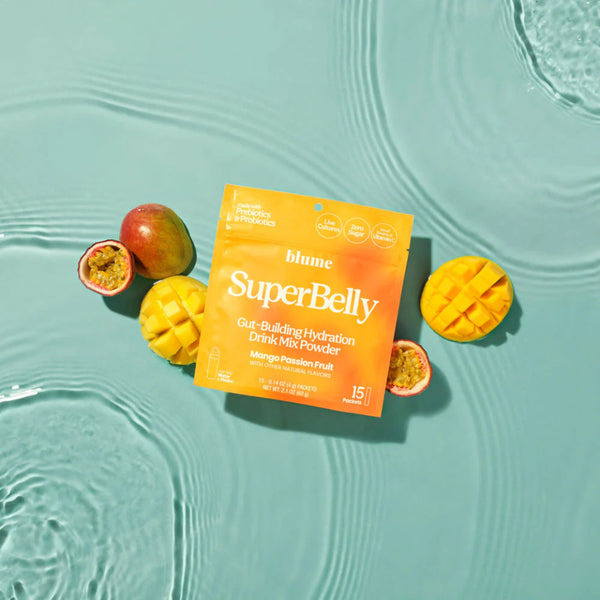 Blume SuperBelly drink mix powder package with mangoes and passion fruit on a teal water background
