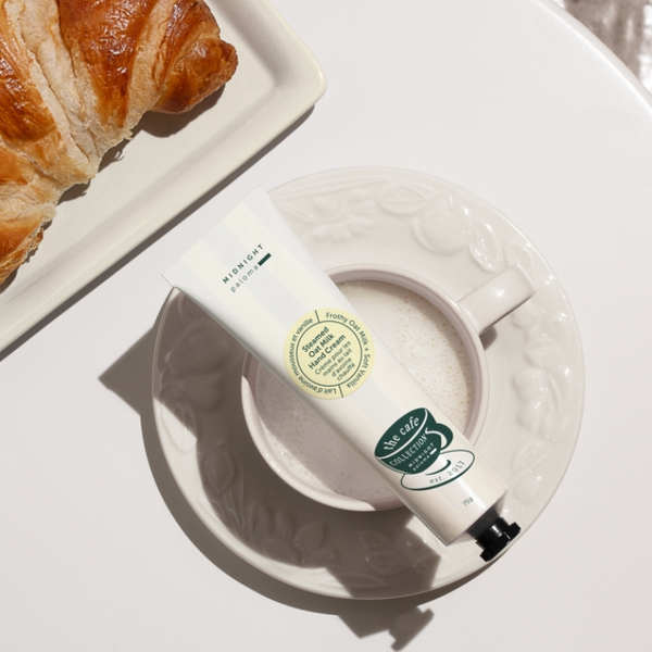 Hand cream tube on a white plate with a croissant on a white surface