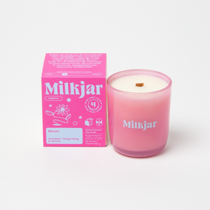 Pink candle and packaging with 'Milkjar' branding on a white background