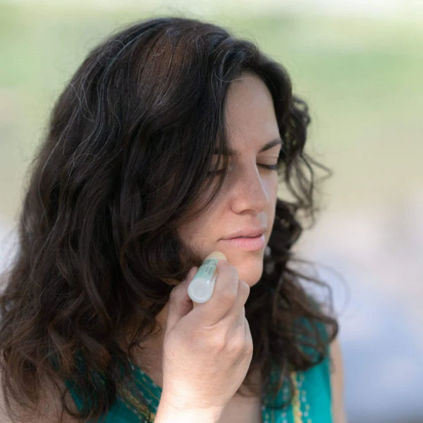person using Rocky Breakout Buster spot treatment stick