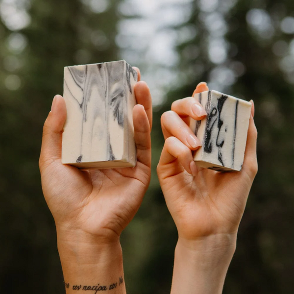 People holding bars of Rocky Fennel & Charcoal cold pressed soap