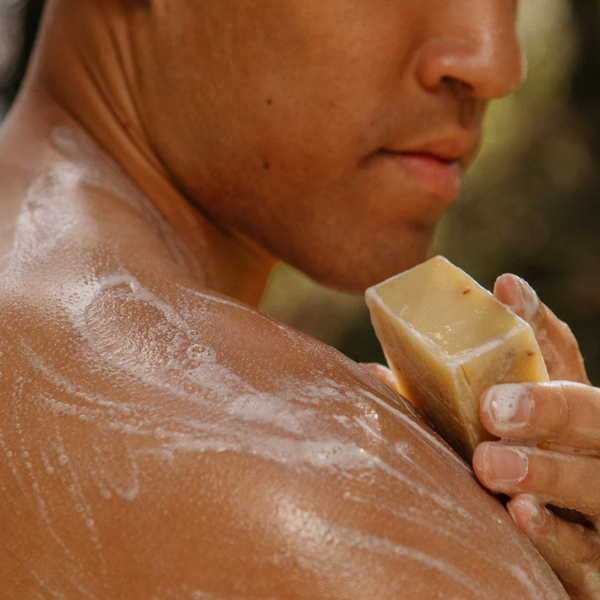 person washing themselves with a bar of Rocky cold pressed lemongrass bar soap