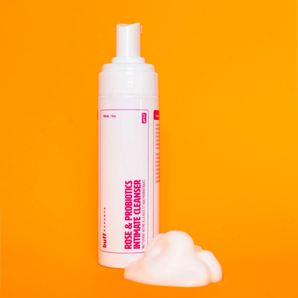 Foam cleanser bottle with pink label on an orange background