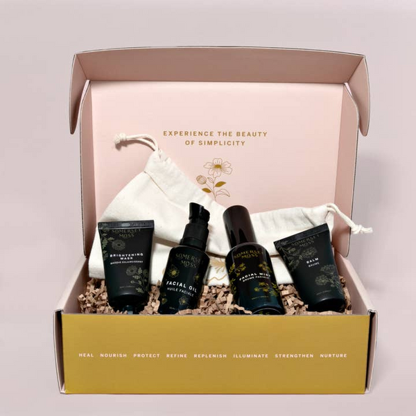 Skincare product set in a box with a drawstring bag and text on a light pink background