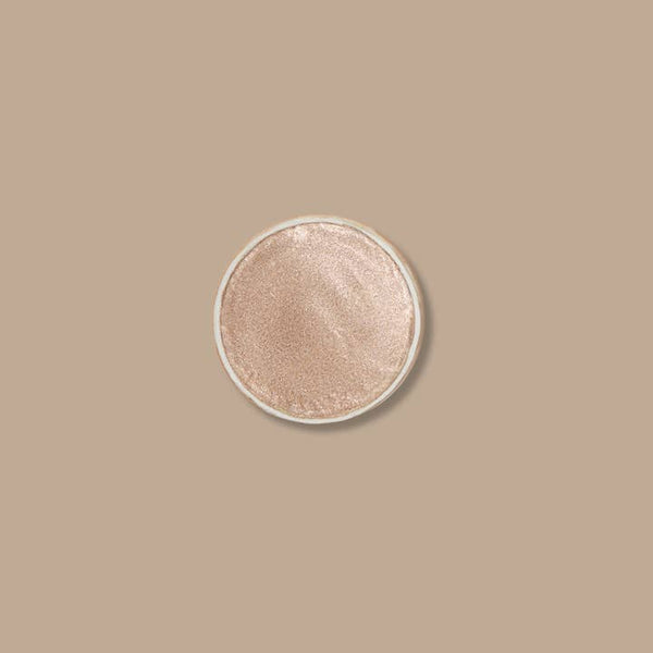 Round makeup compact with beige shade on a beige background