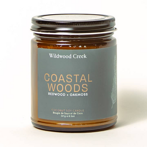 Candle jar labeled 'Coastal Woods' by Wildwood Creek on a white background