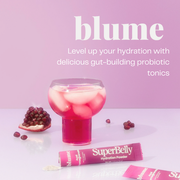 Pink drink with ice and pomegranate pieces, blume SuperBelly hydration powder on a pink background