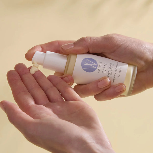 Hands holding a bottle of Micellar Calm Face Lotion against a beige background