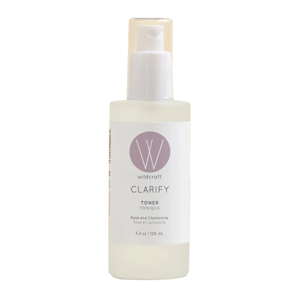 A bottle of Wildcraft Clarify Toner with a white pump dispenser and clear cap, set against a soft beige background.