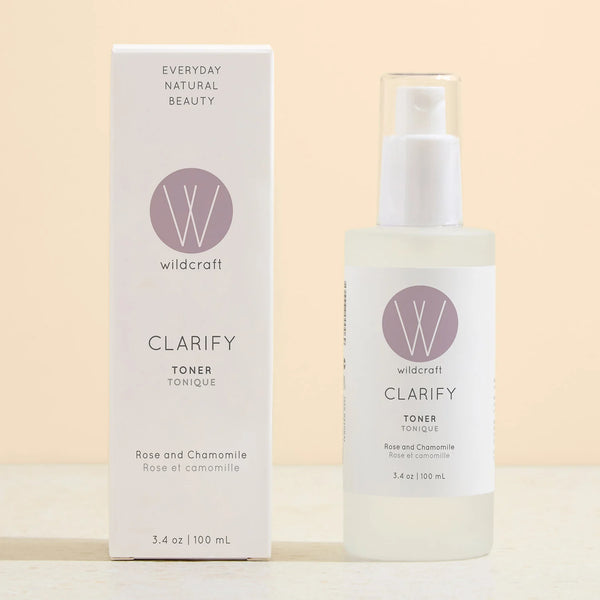 Wildcraft Clarify Toner bottle next to its white packaging box, featuring a rose and chamomile scent, on a light beige background.