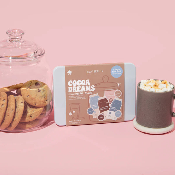 Cocoa Dreams Skincare Treats Set packaging with cookies and a mug on a pink background