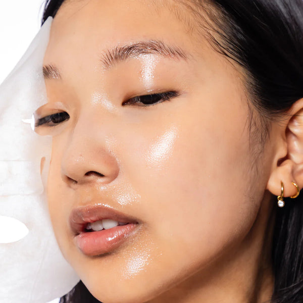 Close-up of a person's face with a focus on the skin texture and lighting as they are pulling off a face mask.