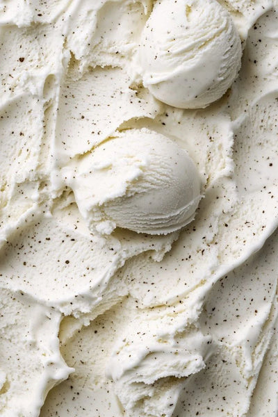 Close-up of creamy vanilla ice cream with specks, likely chocolate chips.